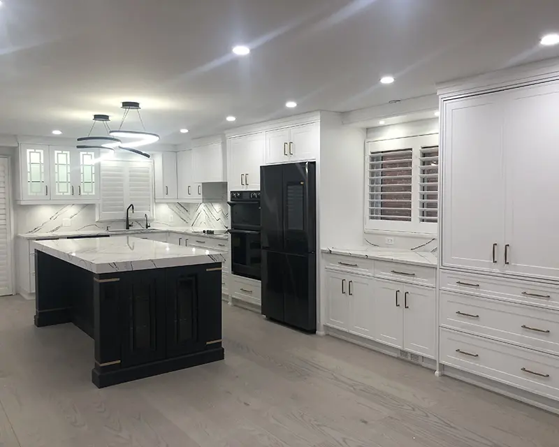 Renovated white kitchen with recessed pot lights, a lit island and a linear pendant