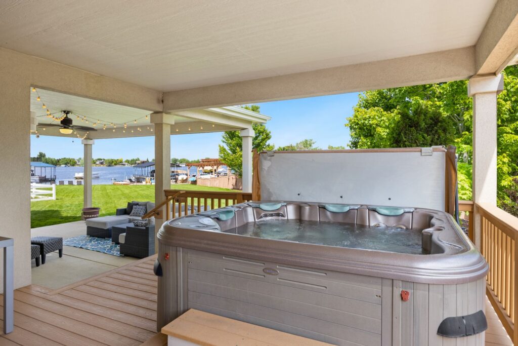 Hot tub on a covered back deck with outdoor seating